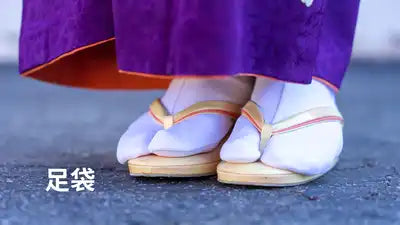 Chaussettes à doigts portées avec des sandales japonaises traditionnelles sur un sol en béton.