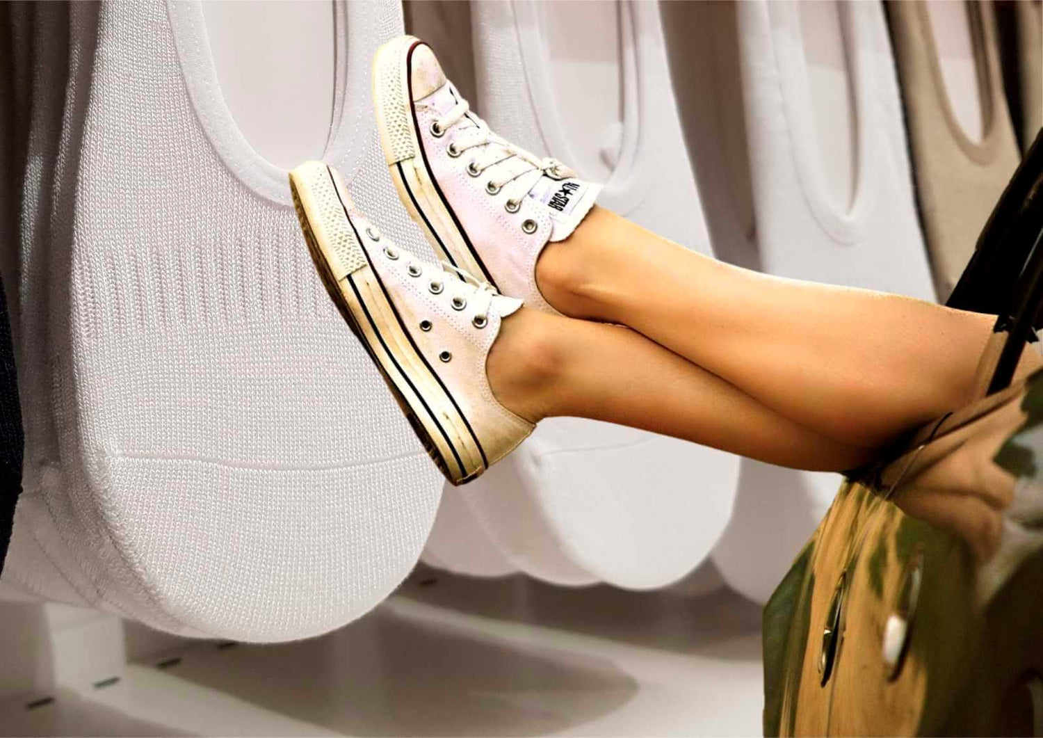 Pieds de femme en baskets et chaussettes invisibles qui sortent la portière d'une voiture