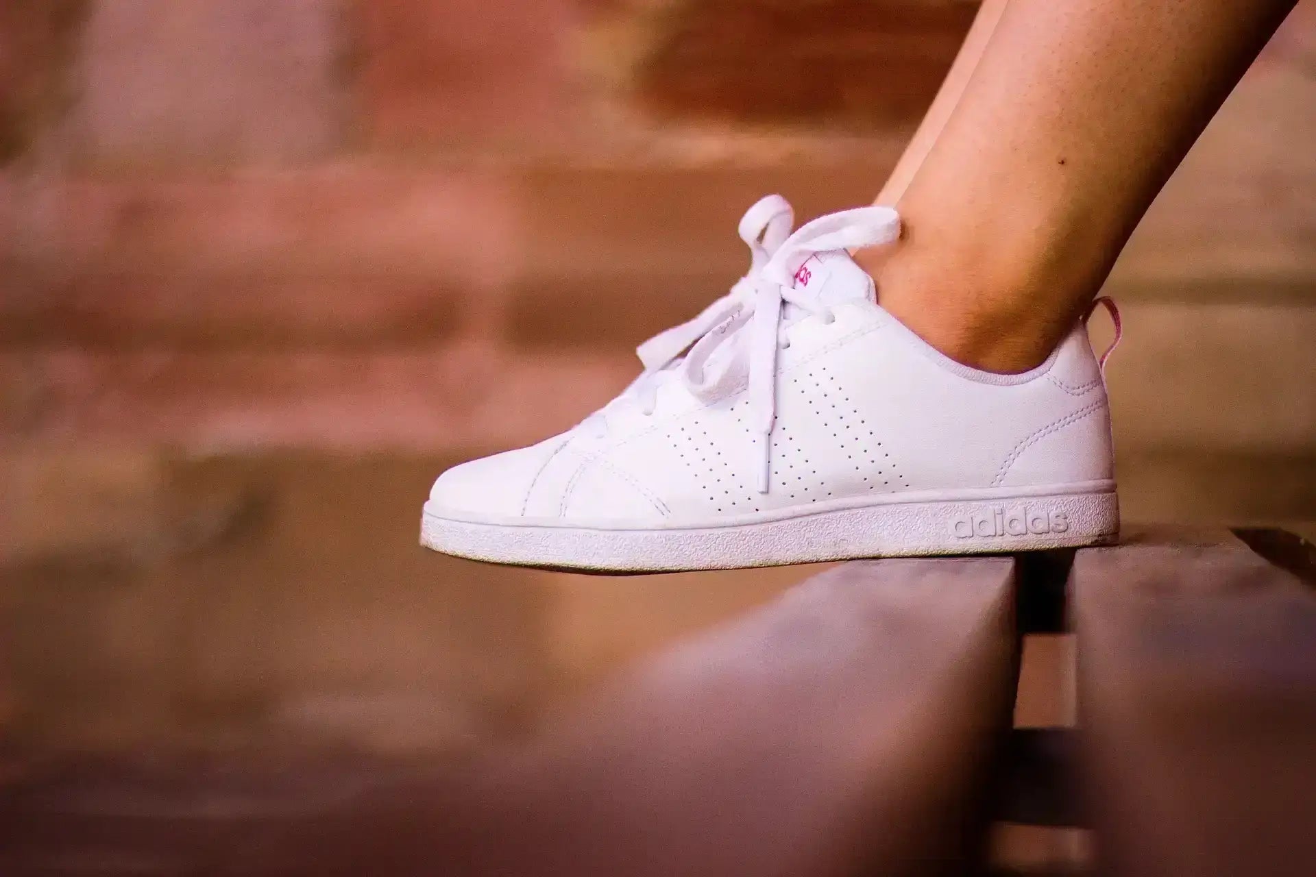 Chaussettes dans les baskets avec des chaussures blanches sur un banc en bois