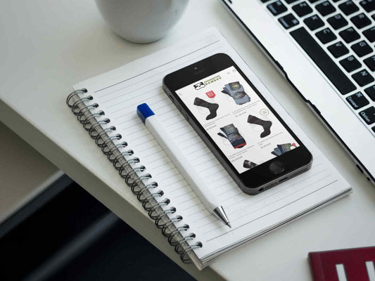 Cahier et stylo sur le bureau avec le smartphone pour préparer la rentrée en achetant ses chaussettes sur le site de vente en ligne de chaussettes-bambou.fr