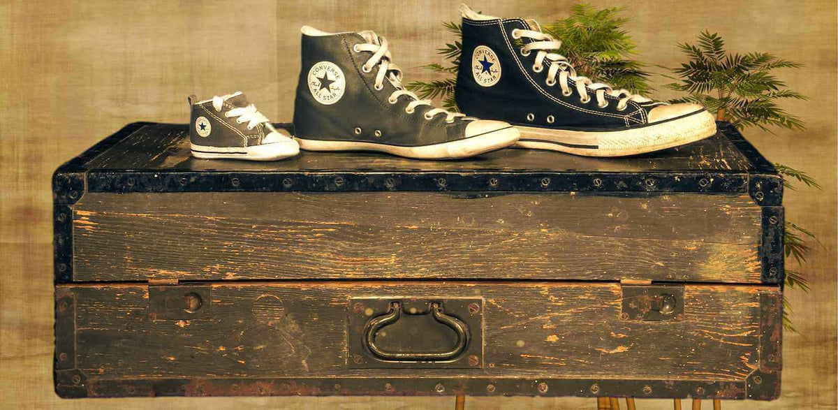 Chaussettes grande taille homme avec des baskets sur une vieille malle en bois.
