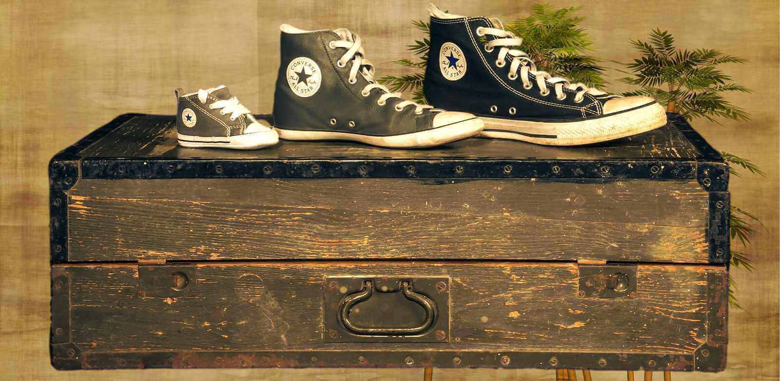 Chaussettes grande taille homme avec des baskets sur une vieille malle en bois.