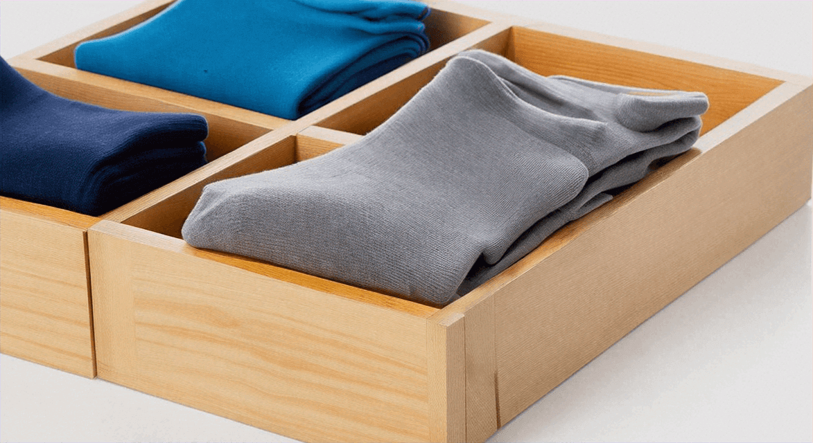 Chaussettes indispensables pour la rentrée présentées dans un tiroir en bois organisé.
