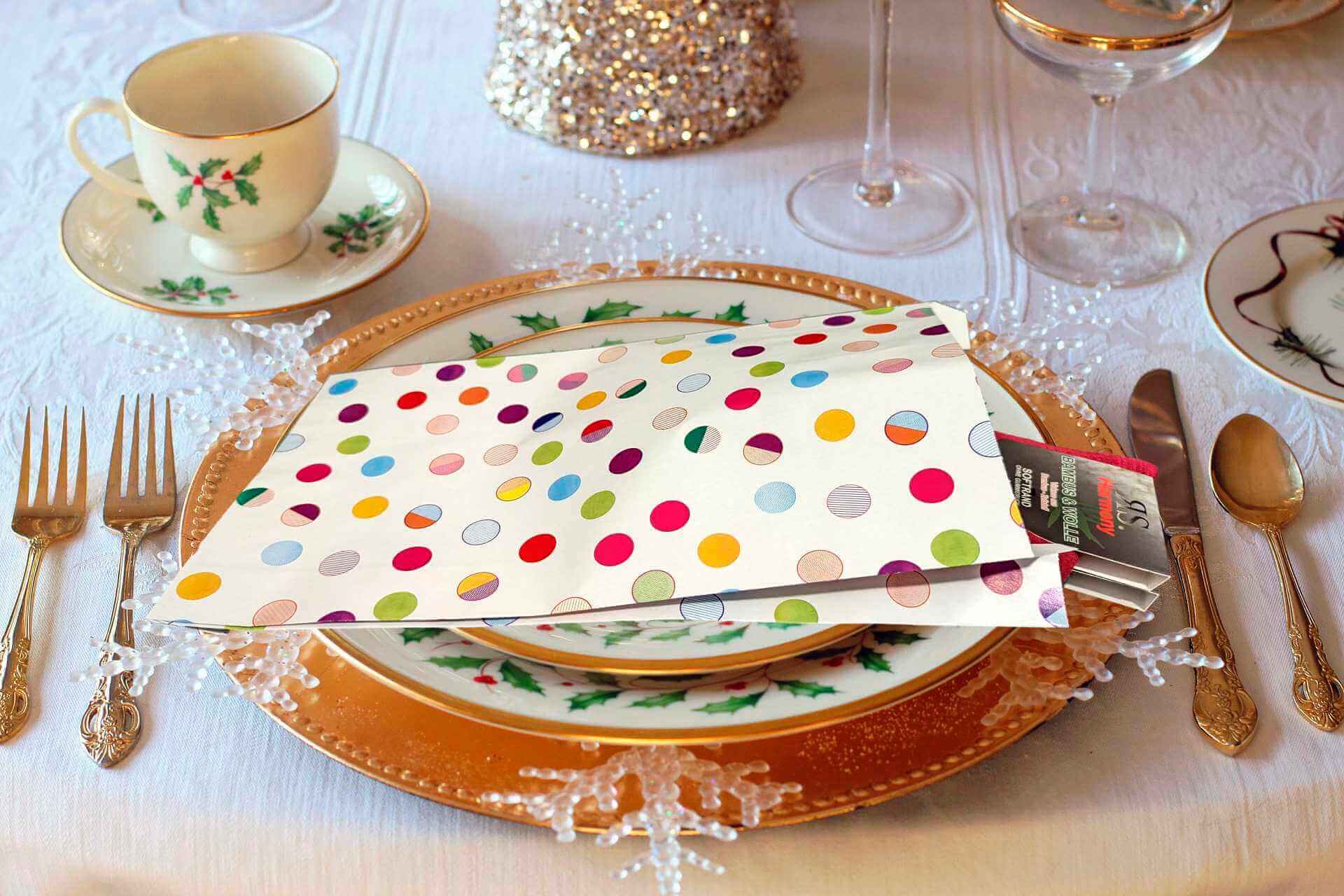 Des pochettes cadeaux dans les assiettes des invités sur une table de réveillon et de fête