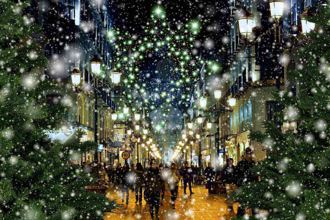 Rue animée illuminée pendant les fêtes avec des décorations de Noël et des flocons de neige, idéale pour offrir des chaussettes bambou.