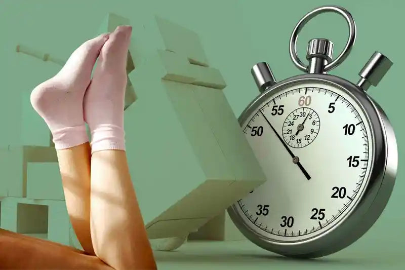 Femme en chaussettes bambou allongée devant des colis d'expédition et un chronomètre.