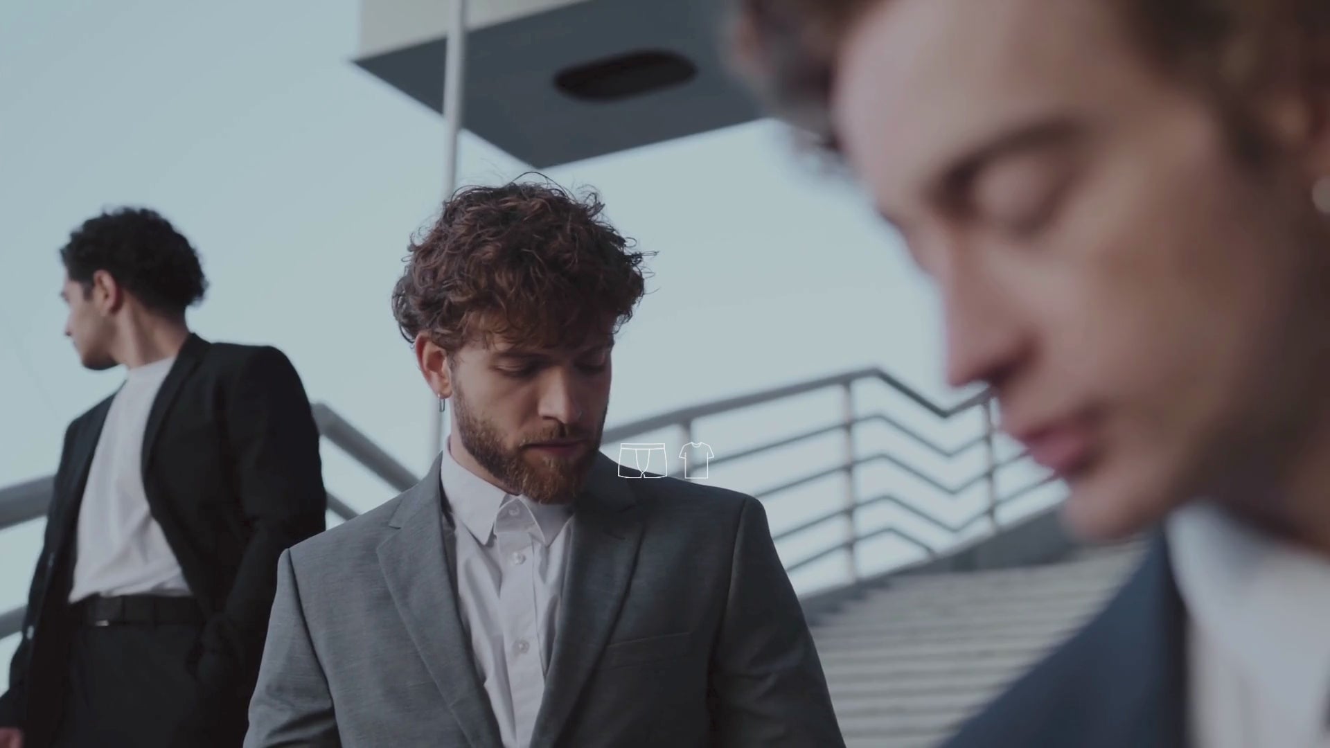 Trois jeunes mannequins homme présentent une collection de vêtements et chaussettes
